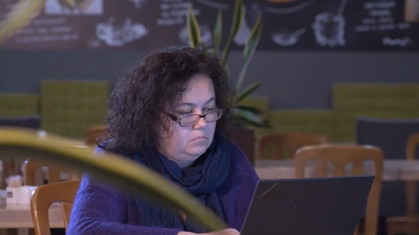 A middle-aged woman sits in front of her laptop in our Kyiv office.