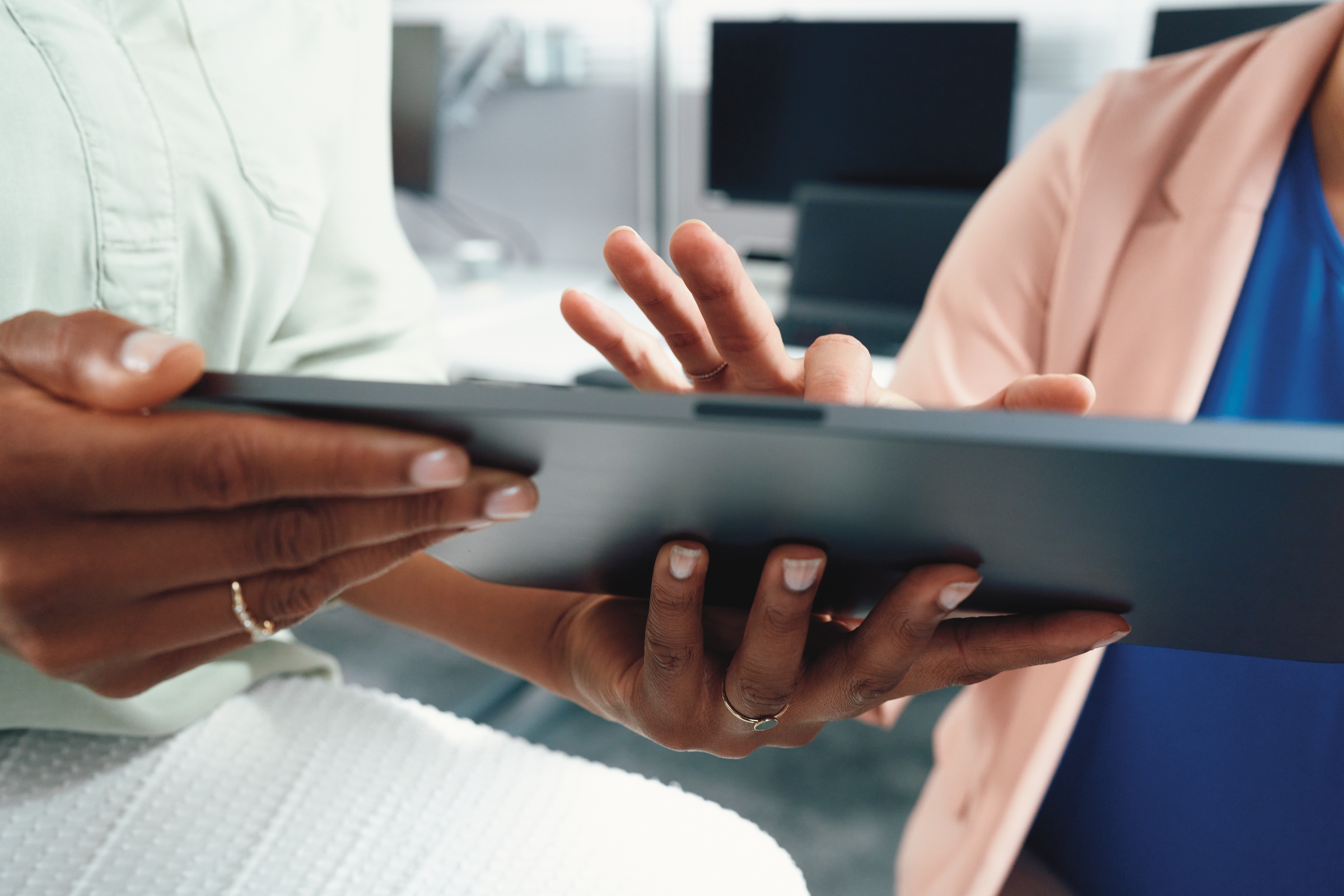 Two colleagues discussing content on digital device.